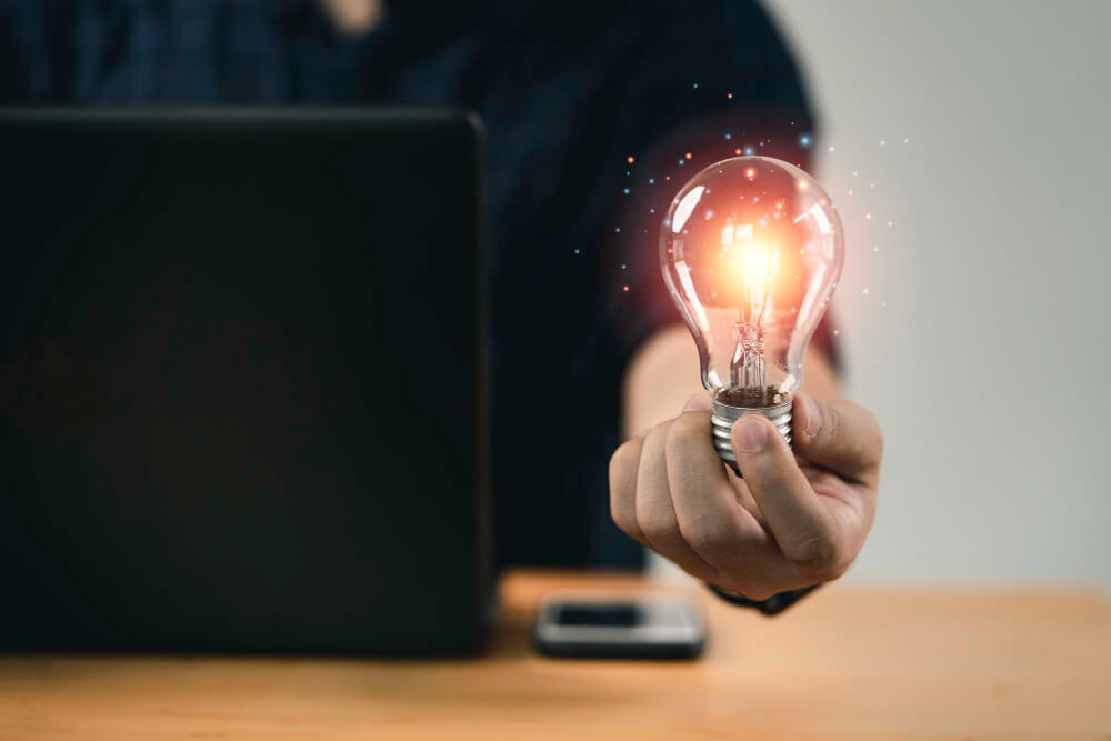 businessman hand holding a lightbulb with glowing light